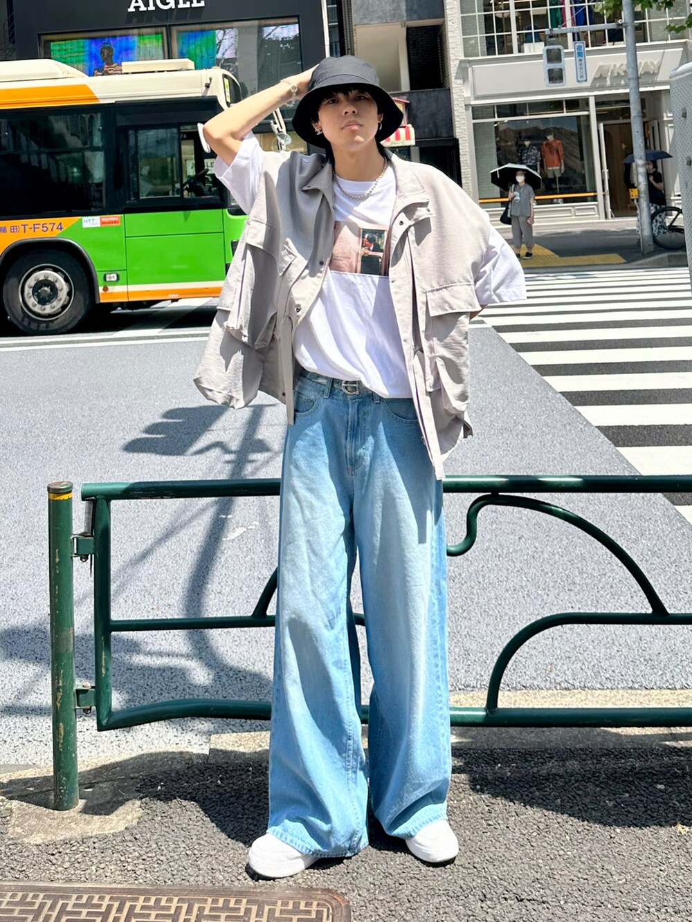 ブルー系のデニムパンツ、ホワイト系のTシャツ/カットソー、ホワイト系のスニーカーを着用したメンズの夏コーディネートの3枚目の写真