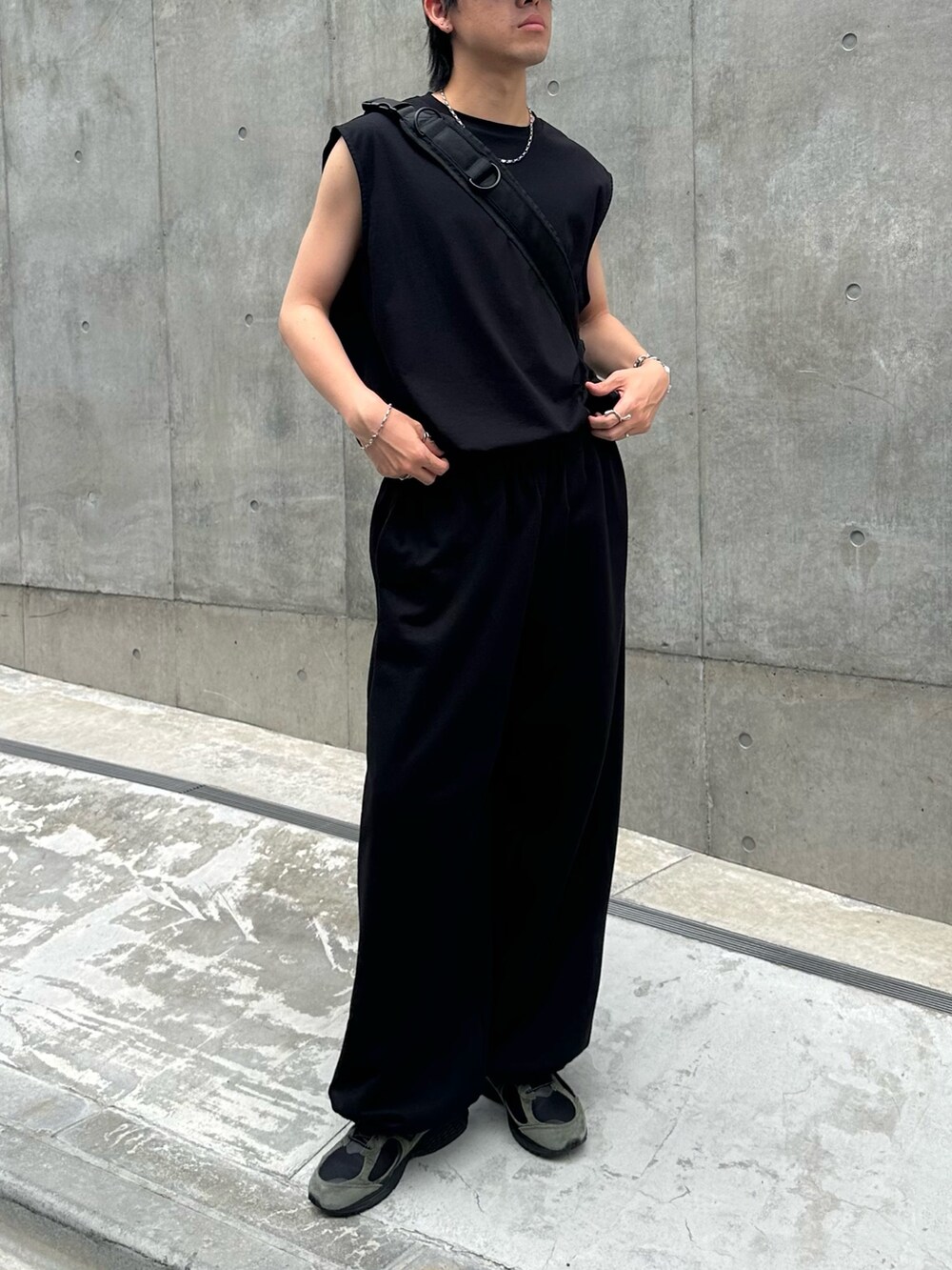 ホワイト系のTシャツ/カットソー、ブラック系のショルダーバッグ、グレー系のスウェットパンツを着用したメンズの夏コーディネートの3枚目の写真