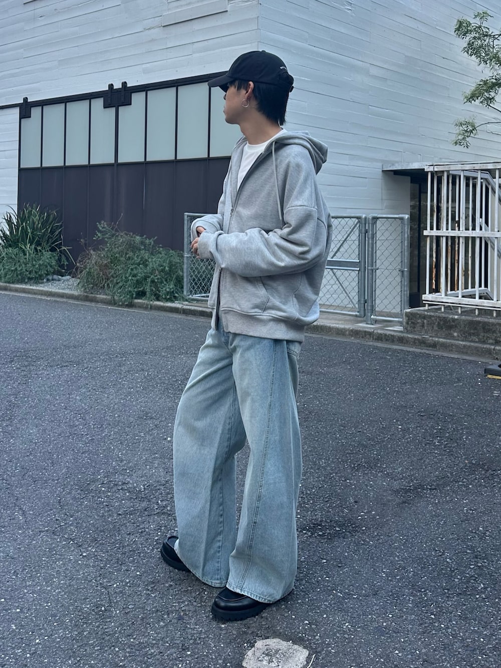 ブラック系のバックパック/リュック、グレー系のパーカー、ブルー系のデニムパンツを着用したメンズの秋コーディネートの3枚目の写真