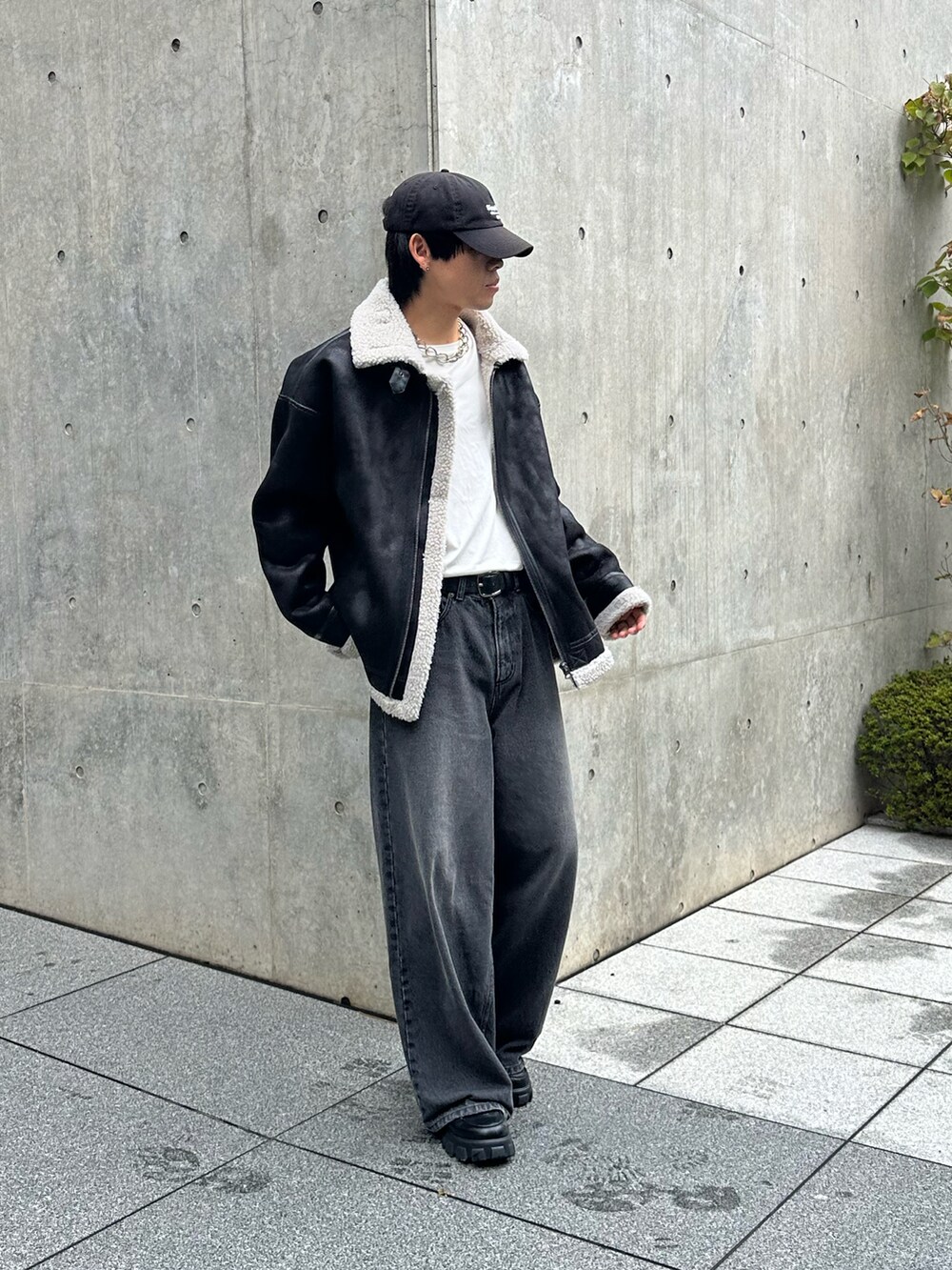 ブラック系のデニムパンツ、ブラック系のムートンコート、ブラック系のキャップを着用したメンズの秋コーディネートの2枚目の写真