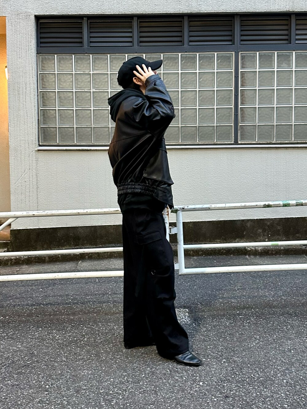 ブラック系のブルゾン、ブラック系のパーカー、ブラック系のカーゴパンツを着用したメンズの冬コーディネートの4枚目の写真