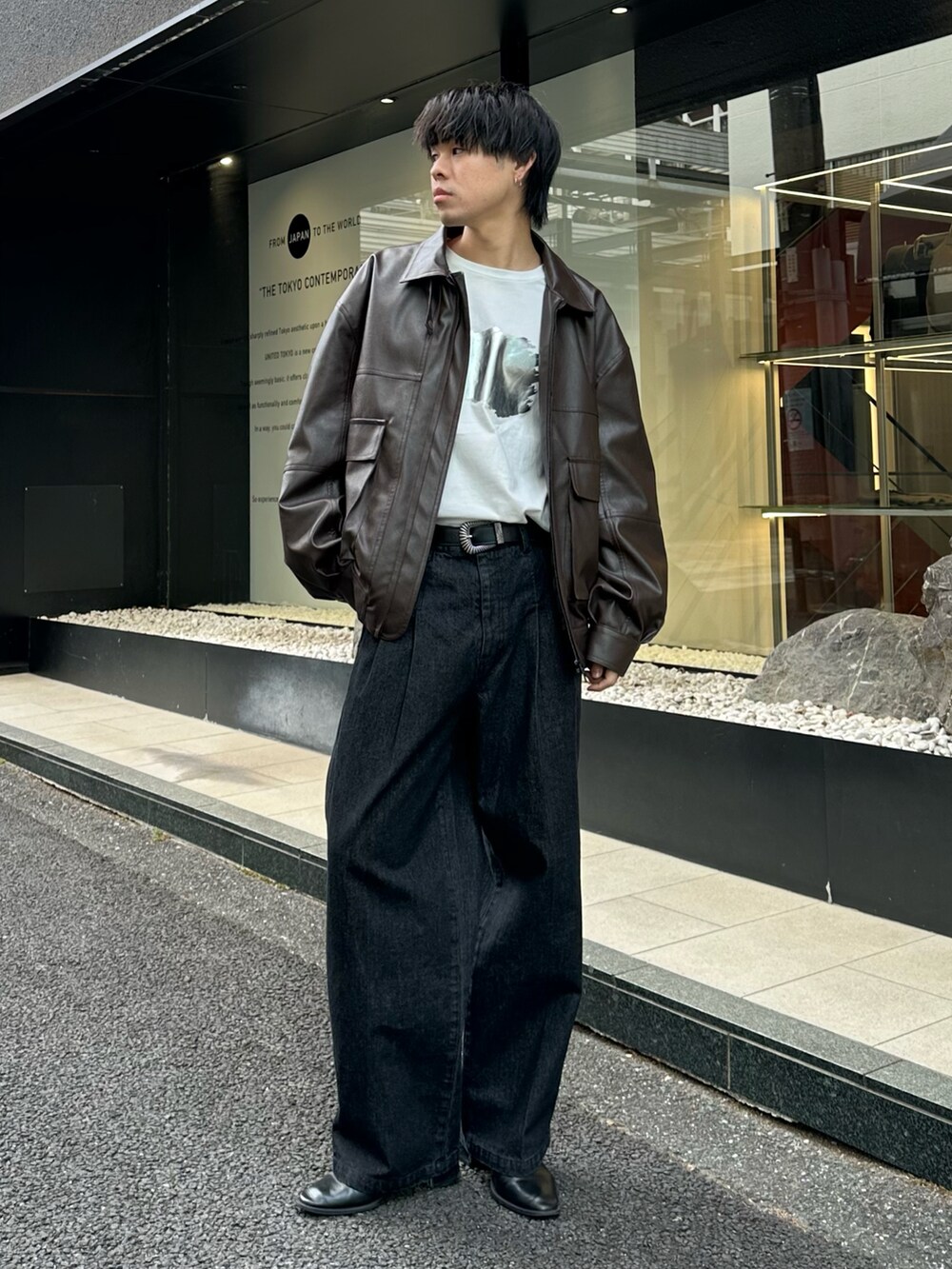 ブラック系のブルゾン、ホワイト系のTシャツ/カットソー、ブラック系のデニムパンツを着用したメンズの冬コーディネートの5枚目の写真