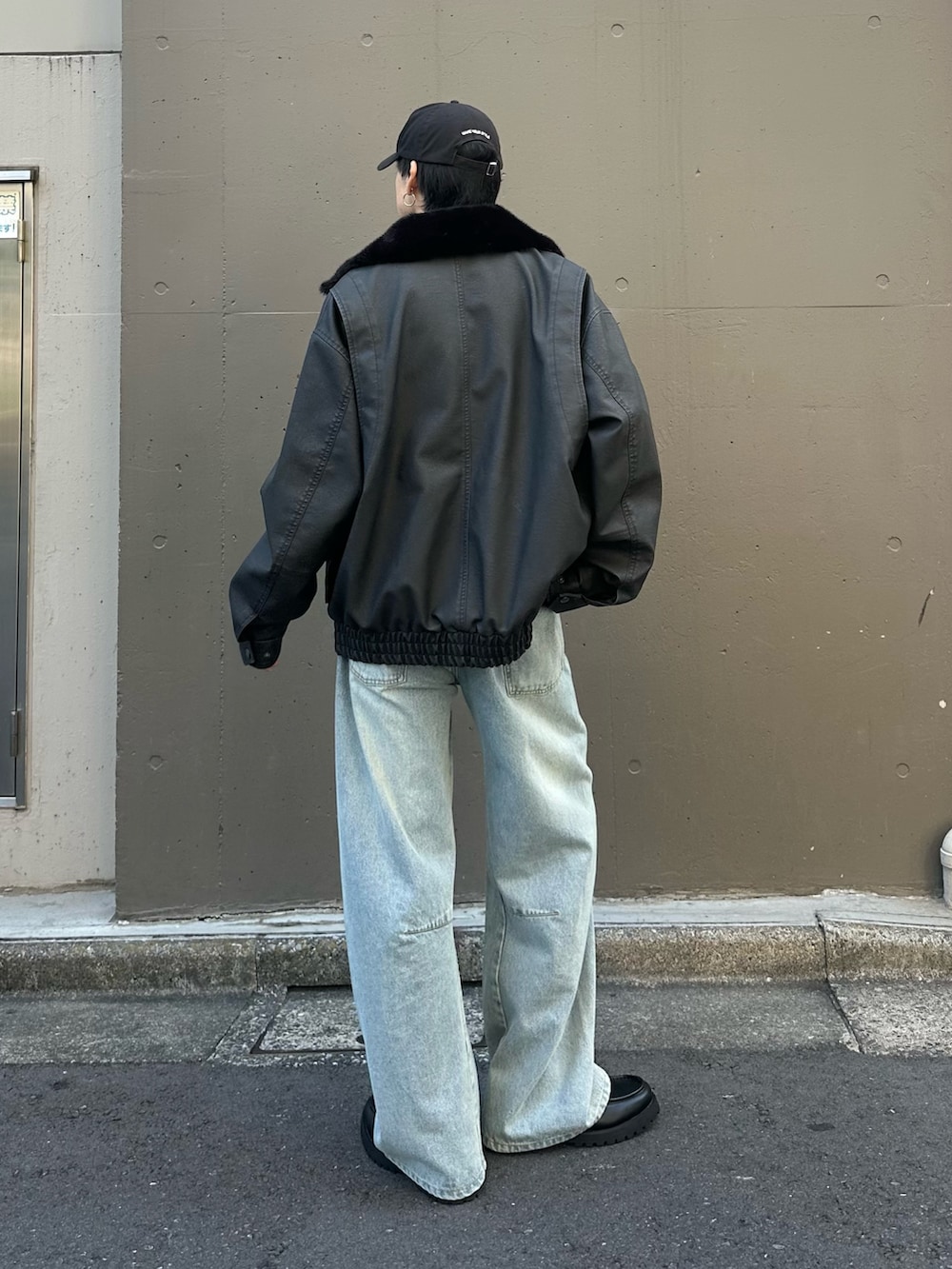 ブルー系のデニムパンツ、ブラック系のドレスシューズ、ブラック系のブルゾンを着用したメンズの秋コーディネートの3枚目の写真