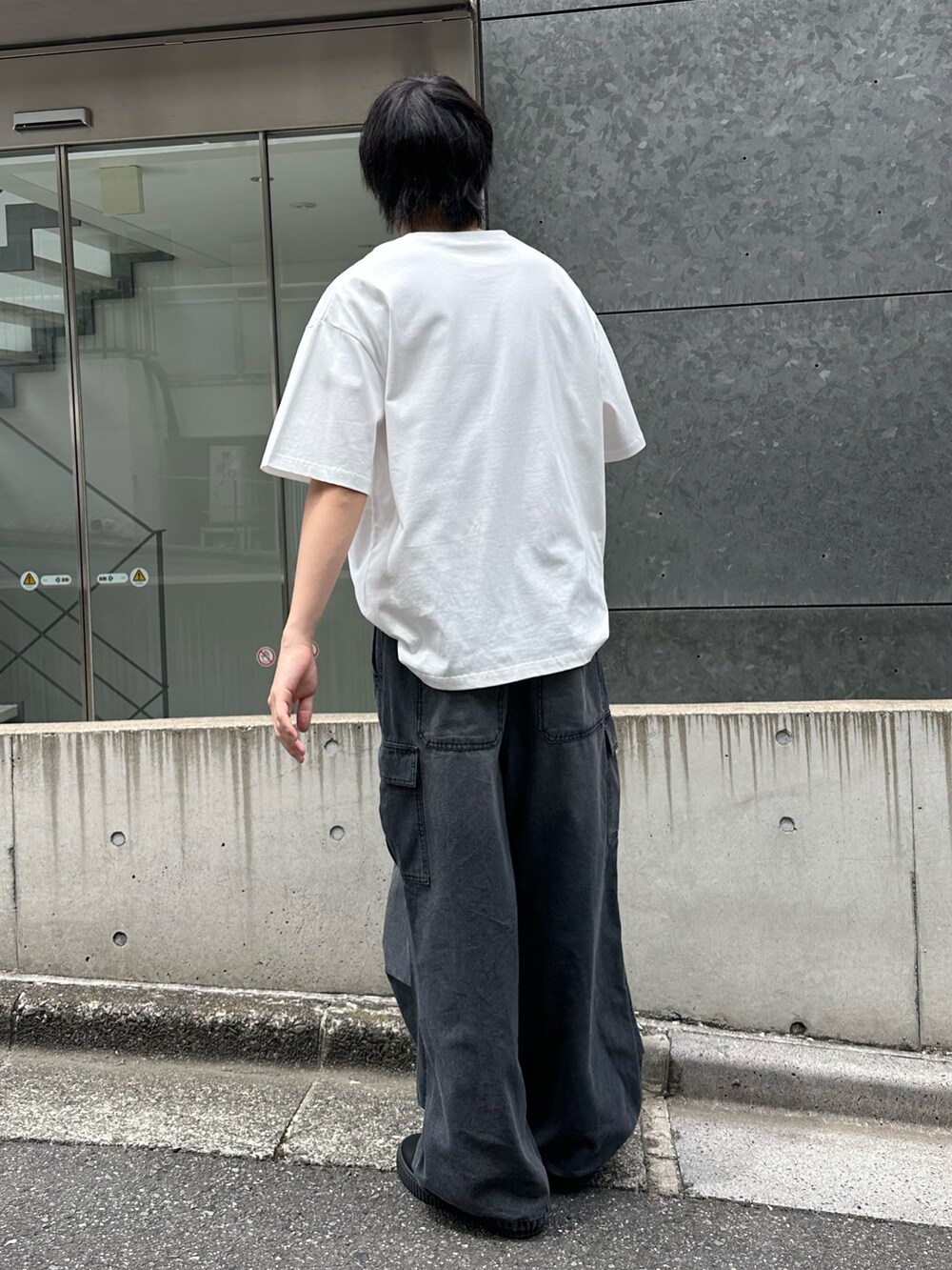 ホワイト系のTシャツ/カットソー、ブラック系のデニムパンツを着用したメンズの春コーディネートの3枚目の写真