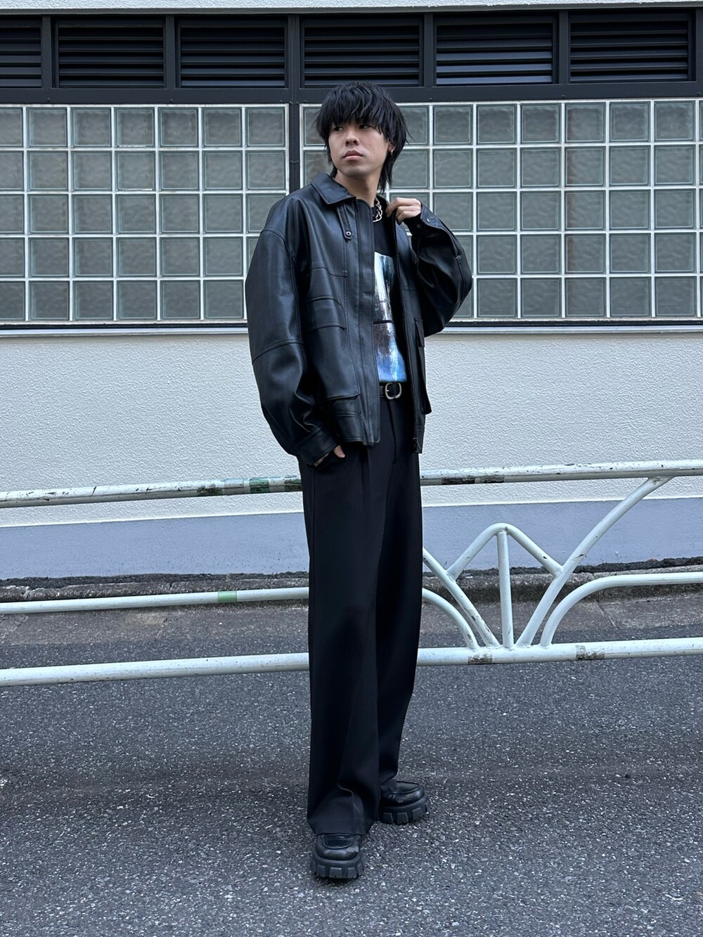 ブラック系のブルゾン、ブラック系のTシャツ/カットソー、ブラック系のスラックスを着用したメンズの冬コーディネートの2枚目の写真