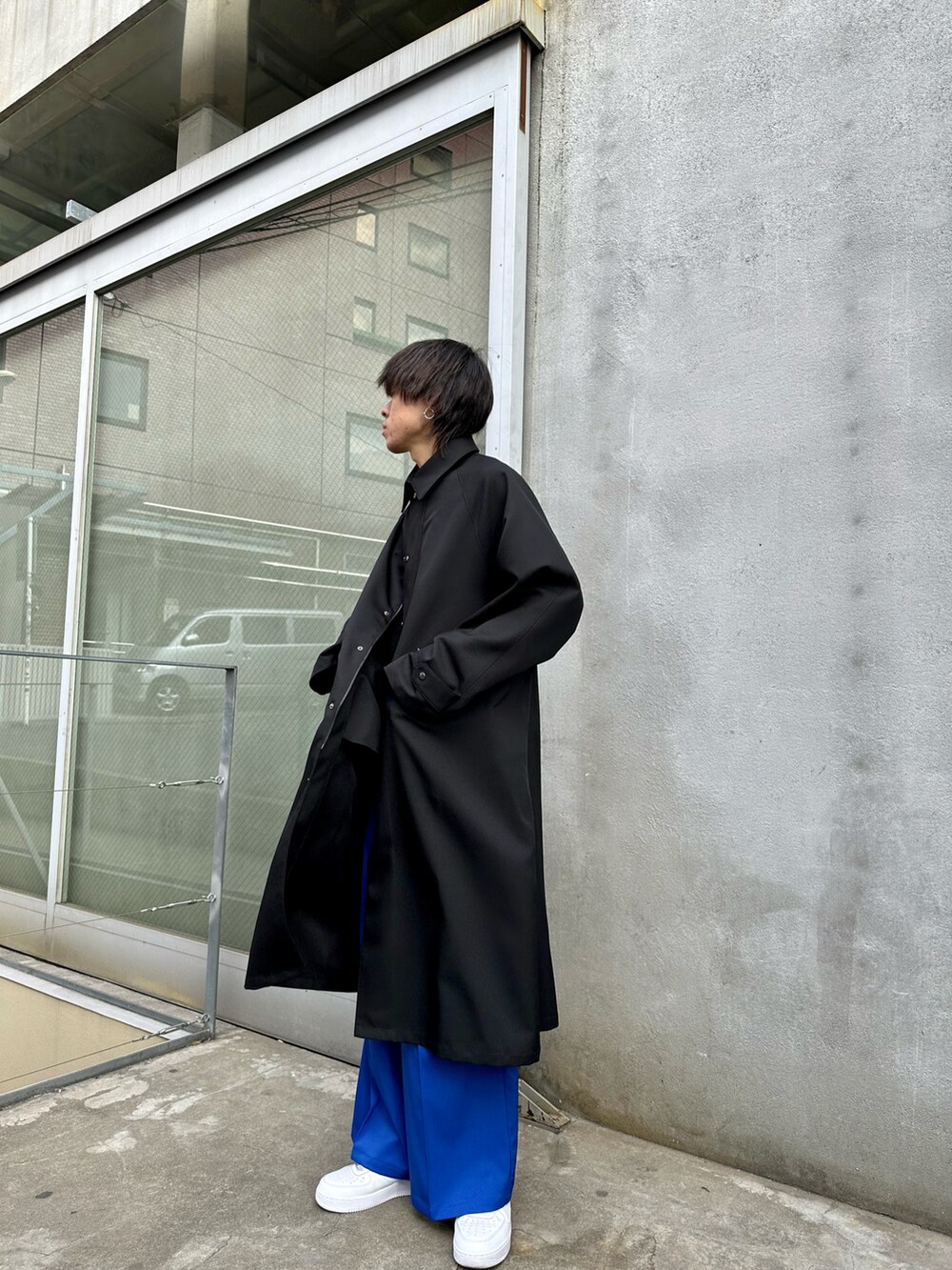 ブラック系のステンカラーコート、ブラック系のニット/セーター、ブルー系のその他パンツを着用したメンズの冬コーディネートの3枚目の写真