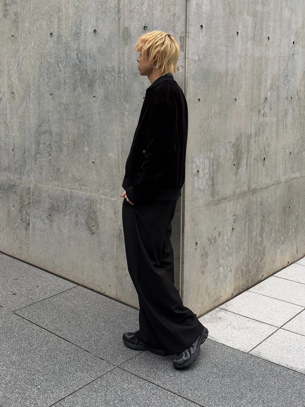 ブラック系のブルゾン、ブラック系のスラックス、ホワイト系のTシャツ/カットソーを着用したメンズの秋コーディネートの2枚目の写真