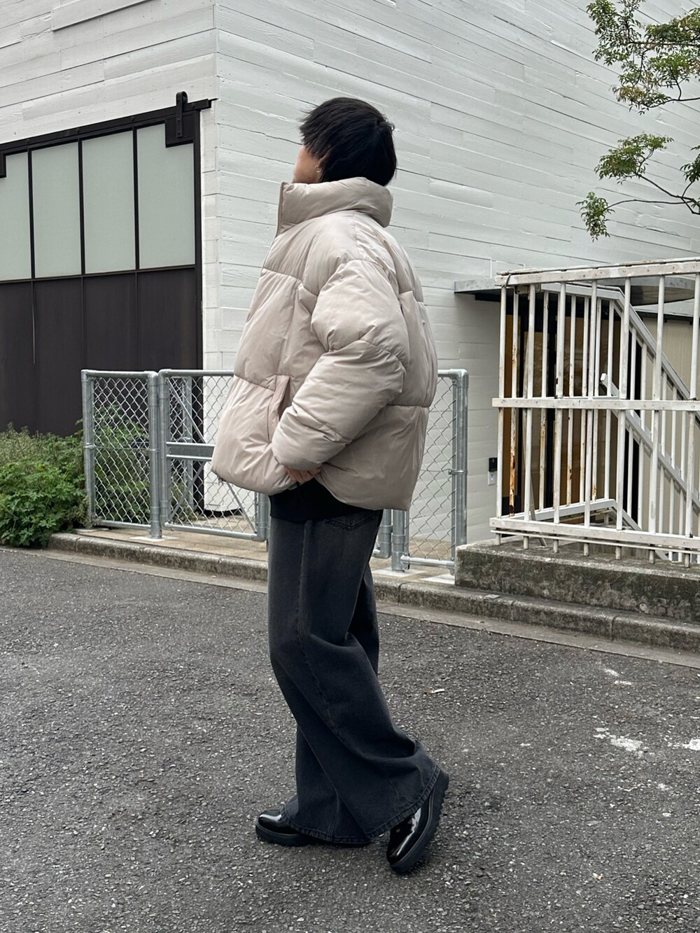 ベージュ系のダウンジャケット/コート、ブラック系のデニムパンツ、ブラック系のニット/セーターを着用したメンズの冬コーディネートの2枚目の写真