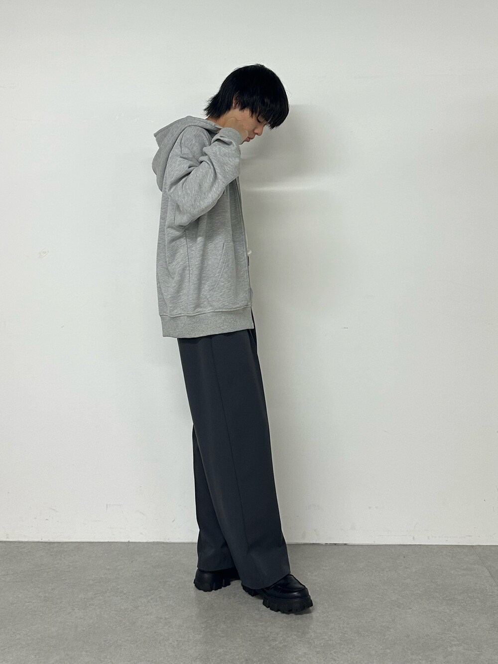 グレー系のパーカー、グレー系のスラックスを着用したメンズの秋コーディネートの2枚目の写真