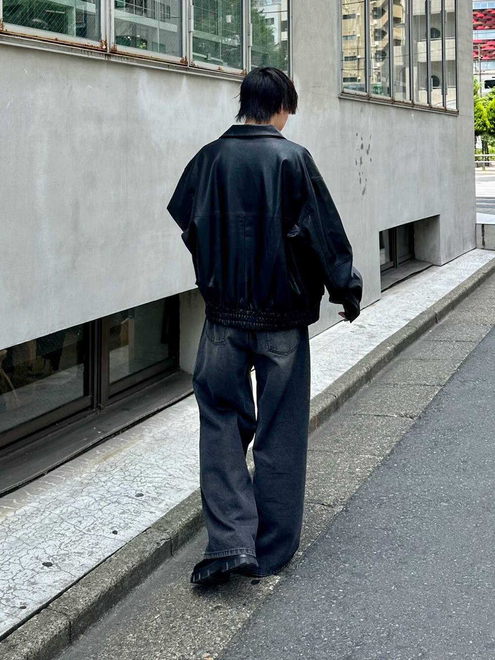 ブラック系のブルゾン、ホワイト系のTシャツ/カットソー、ブラック系のデニムパンツを着用したメンズの夏コーディネートの3枚目の写真