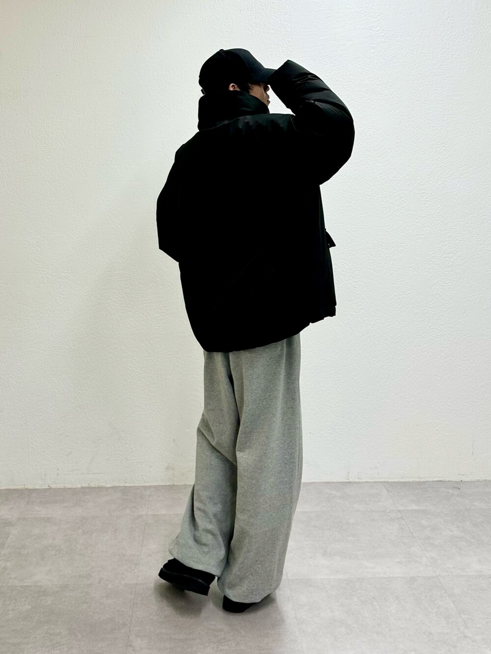 ブラック系のダウンジャケット/コート、グレー系のスウェットパンツ、ブラック系のモカシン/デッキシューズを着用したメンズの冬コーディネートの3枚目の写真