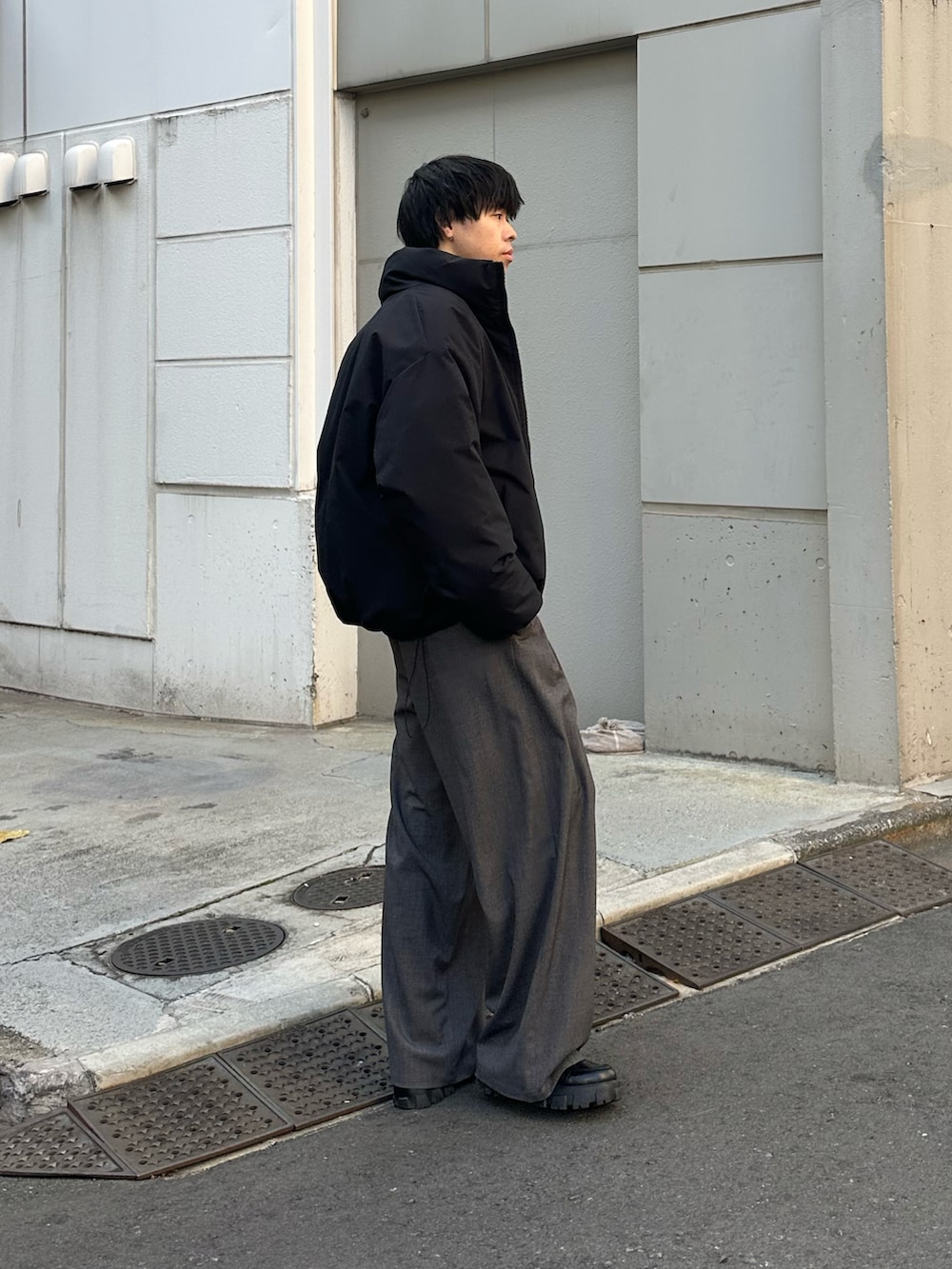 ブラック系のダウンジャケット/コート、グレー系のスラックスを着用したメンズの冬コーディネートの2枚目の写真