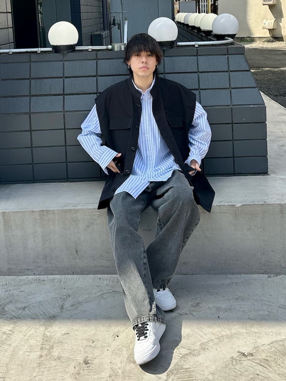 ブラック系のベスト、ホワイト系のシャツ/ブラウス、グレー系のデニムパンツを着用したメンズの春コーディネートの5枚目の写真