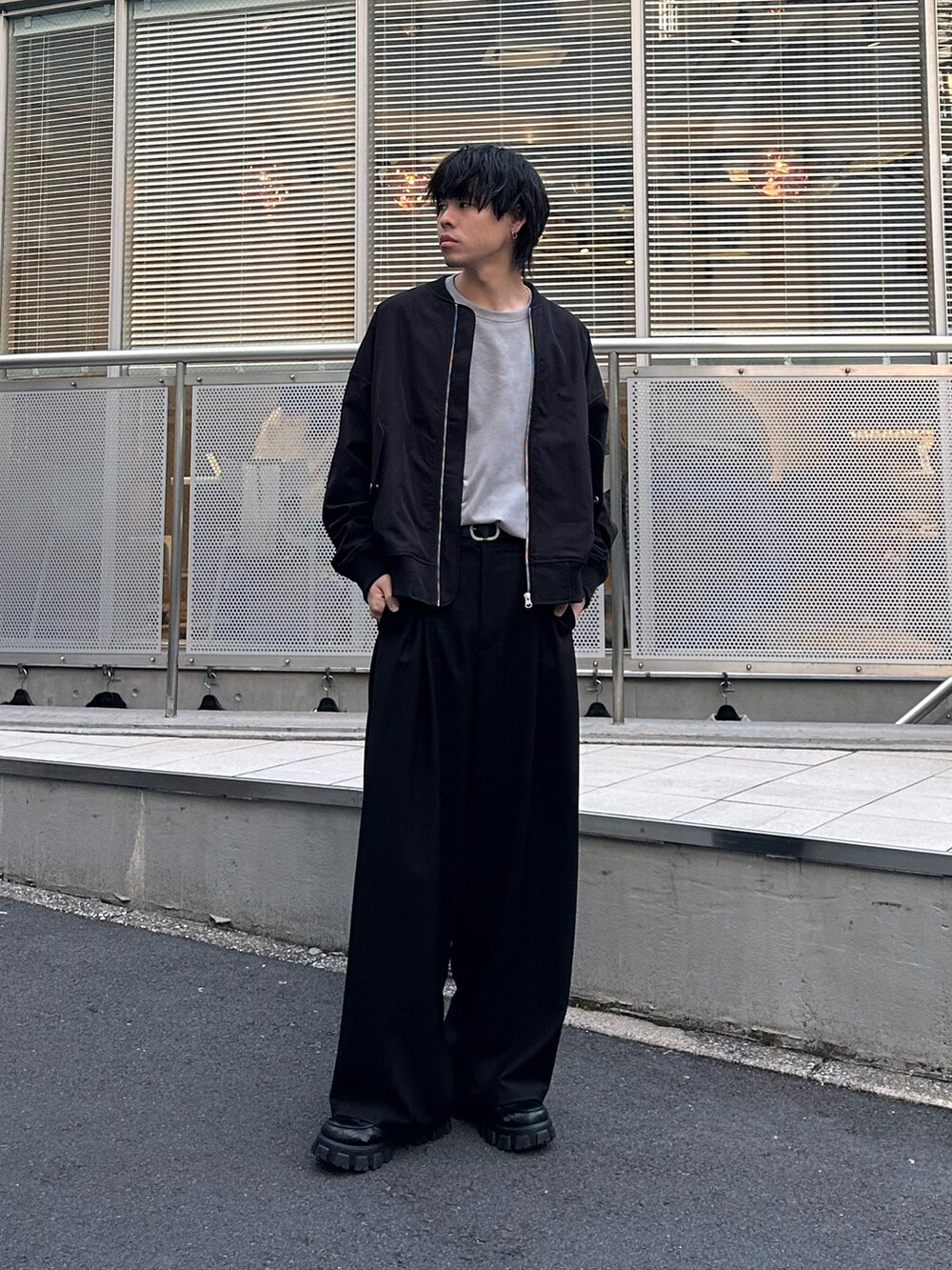 ブラック系のMA-1、グレー系のTシャツ/カットソー、ブラック系のスラックスを着用したメンズの冬コーディネートの2枚目の写真