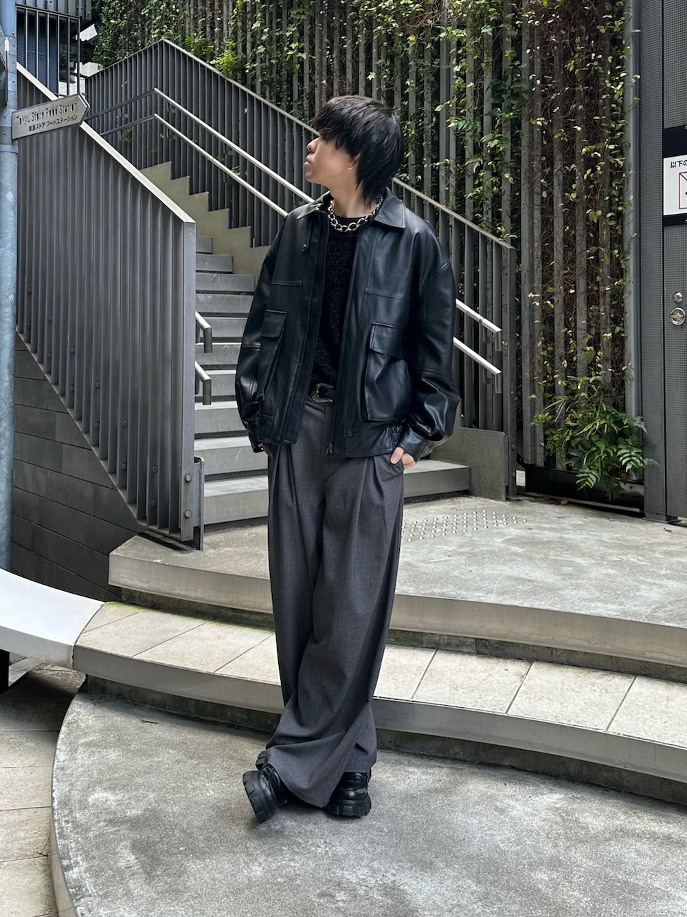 ブラック系のブルゾン、ブラック系のTシャツ/カットソー、グレー系のスラックスを着用したメンズの冬コーディネートの3枚目の写真