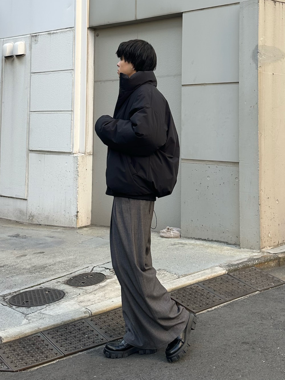ブラック系のダウンジャケット/コート、グレー系のスラックスを着用したメンズの冬コーディネートの4枚目の写真