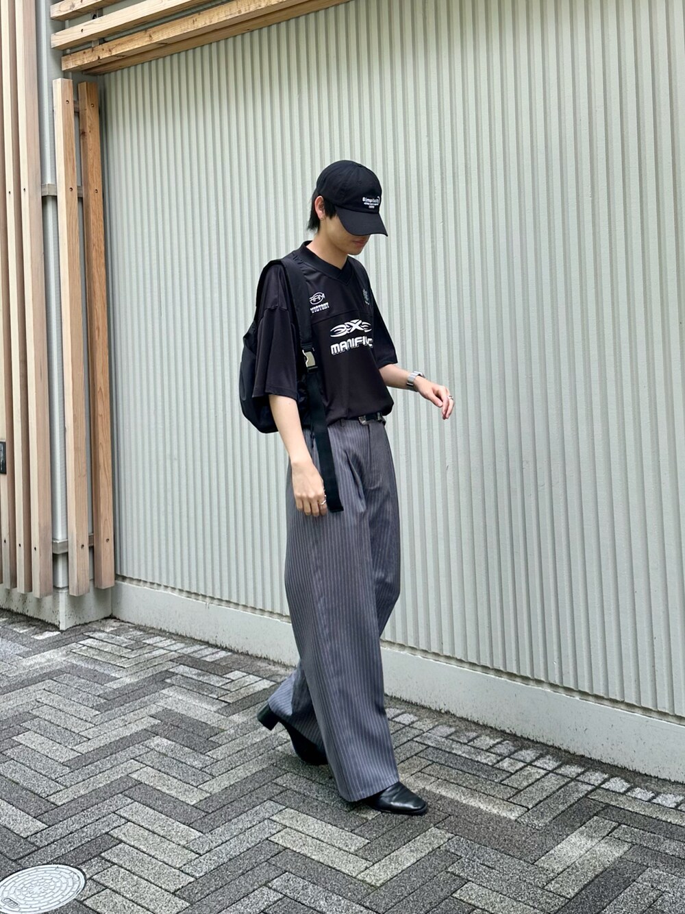 ブラック系のTシャツ/カットソー、ブラック系のショルダーバッグ、ブルー系のキャップを着用したメンズの夏コーディネートの3枚目の写真