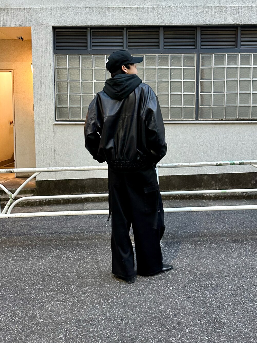 ブラック系のブルゾン、ブラック系のパーカー、ブラック系のカーゴパンツを着用したメンズの冬コーディネートの3枚目の写真