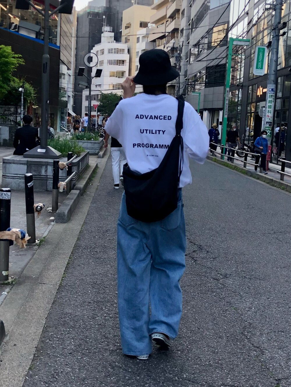 ブラック系のショルダーバッグ、ホワイト系のTシャツ/カットソー、ブルー系のパンツを着用したメンズの夏コーディネートの3枚目の写真