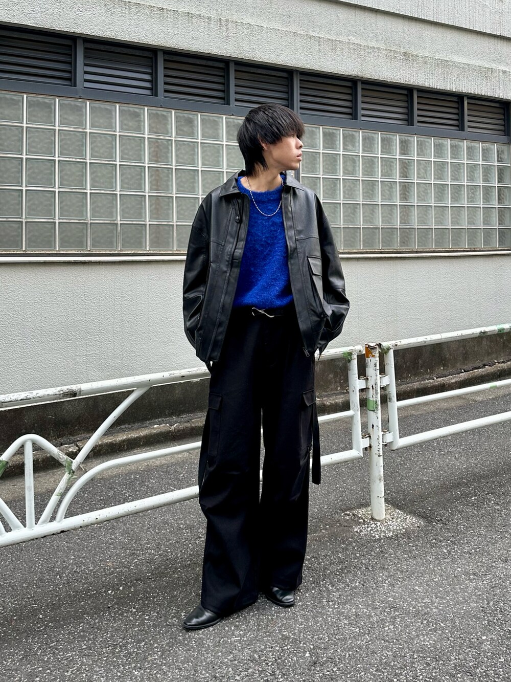 ブラック系のブルゾン、ブルー系のニット/セーター、ブラック系のカーゴパンツを着用したメンズの秋コーディネートの2枚目の写真