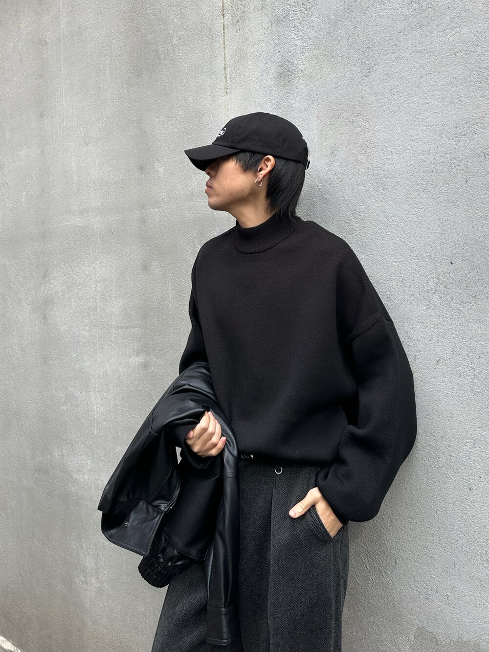 グレー系のスラックス、ブラック系のニット/セーター、ブラック系のブルゾンを着用したメンズの秋コーディネートの4枚目の写真