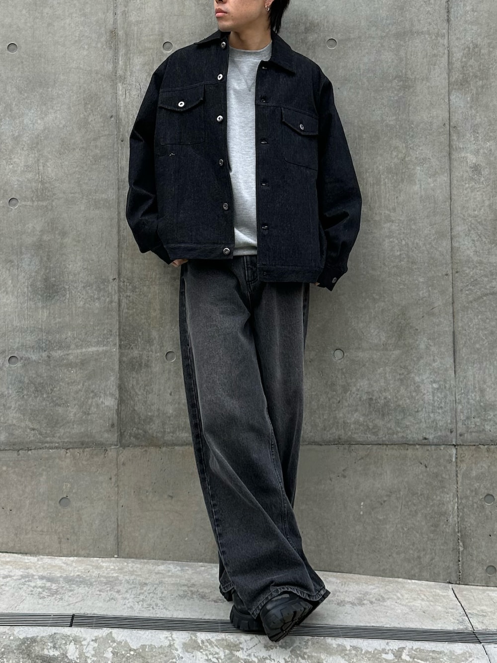 ブラック系のデニムジャケット、グレー系のTシャツ/カットソー、ブラック系のデニムパンツを着用したメンズの冬コーディネートの5枚目の写真