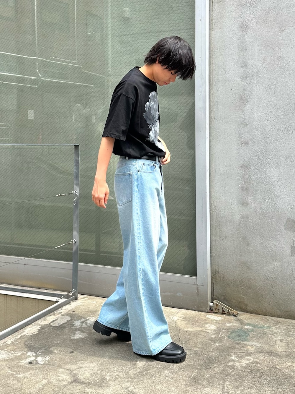 ホワイト系のTシャツ/カットソー、ブルー系のデニムパンツ、ブラック系のベルトを着用したメンズの春コーディネートの4枚目の写真