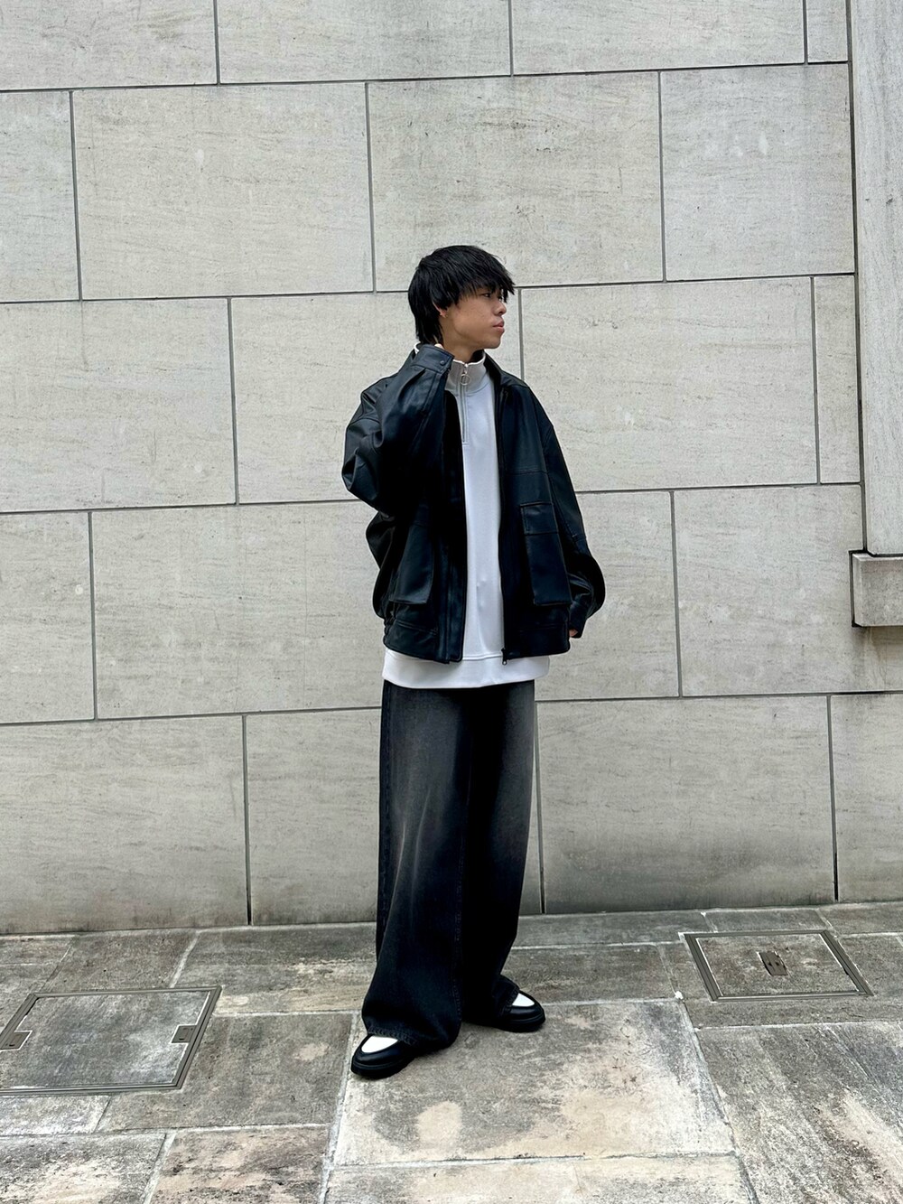 ブラック系のブルゾン、グレー系のTシャツ/カットソー、ブラック系のデニムパンツを着用したメンズの秋コーディネートの3枚目の写真