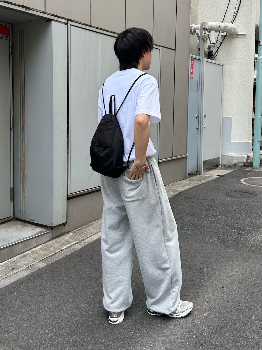 ブラック系のバックパック/リュック、グレー系のスウェットパンツ、ホワイト系のTシャツ/カットソーを着用したメンズの夏コーディネートの4枚目の写真