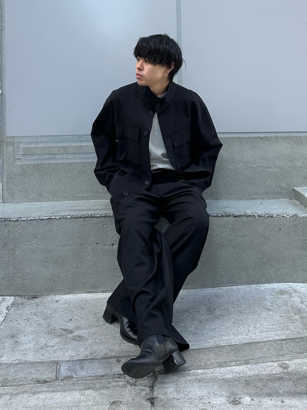 ブラック系のその他アウター、ブラック系のスラックス、ブラック系のベルトを着用したメンズの冬コーディネートの3枚目の写真