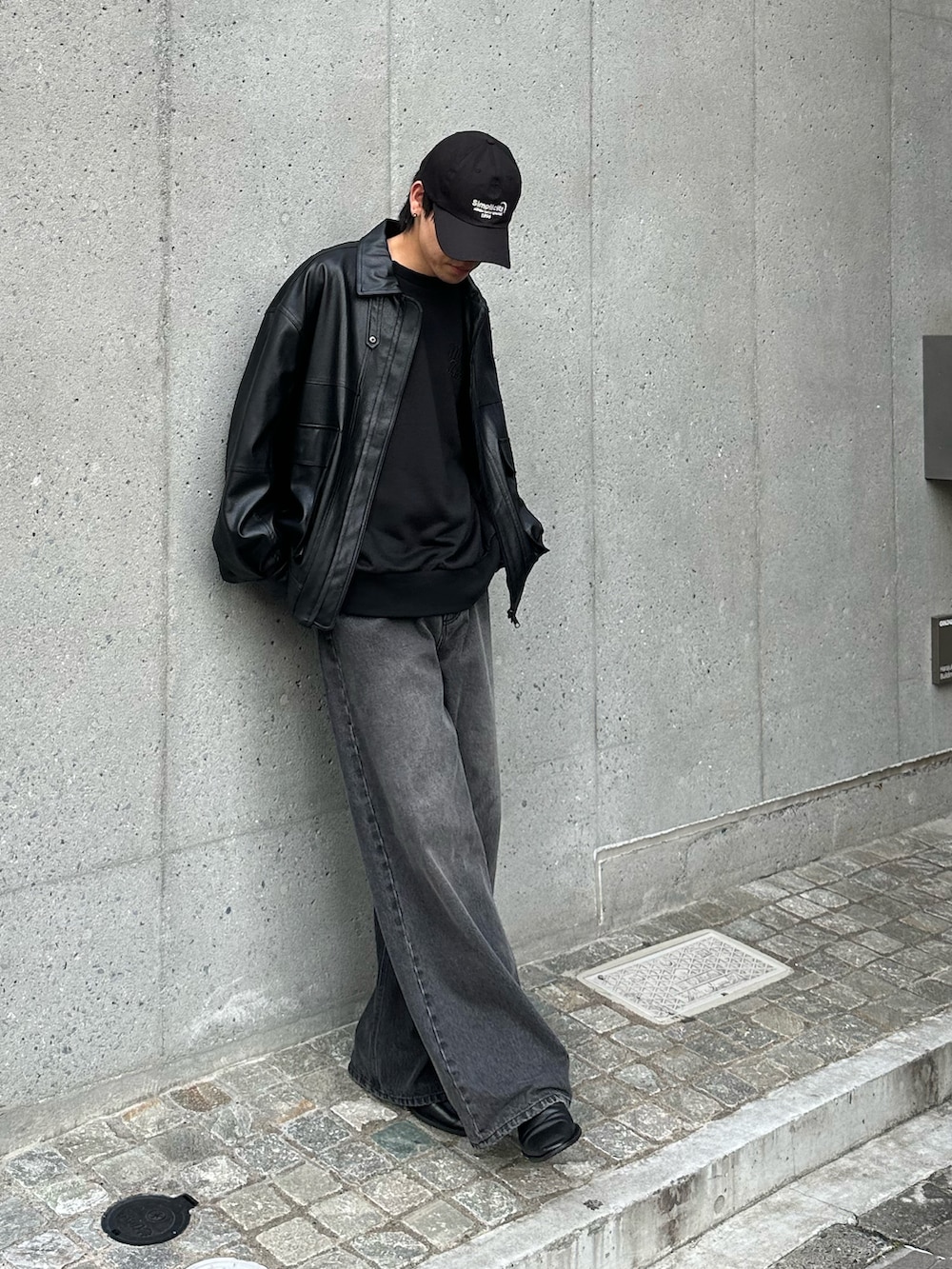 ブラック系のTシャツ/カットソー、ブラック系のデニムパンツ、ブラック系のブルゾンを着用したメンズの秋コーディネートの5枚目の写真