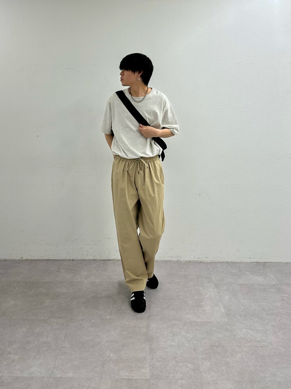 ベージュ系のその他パンツ、ホワイト系のTシャツ/カットソー、ブラック系のショルダーバッグを着用したメンズの春コーディネートの3枚目の写真