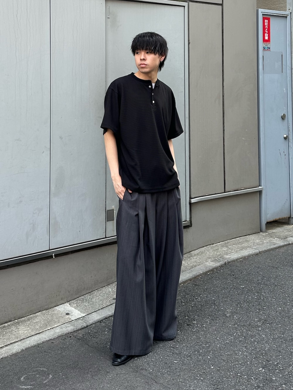 ブラック系のTシャツ/カットソー、グレー系のスラックスを着用したメンズの春コーディネートの5枚目の写真