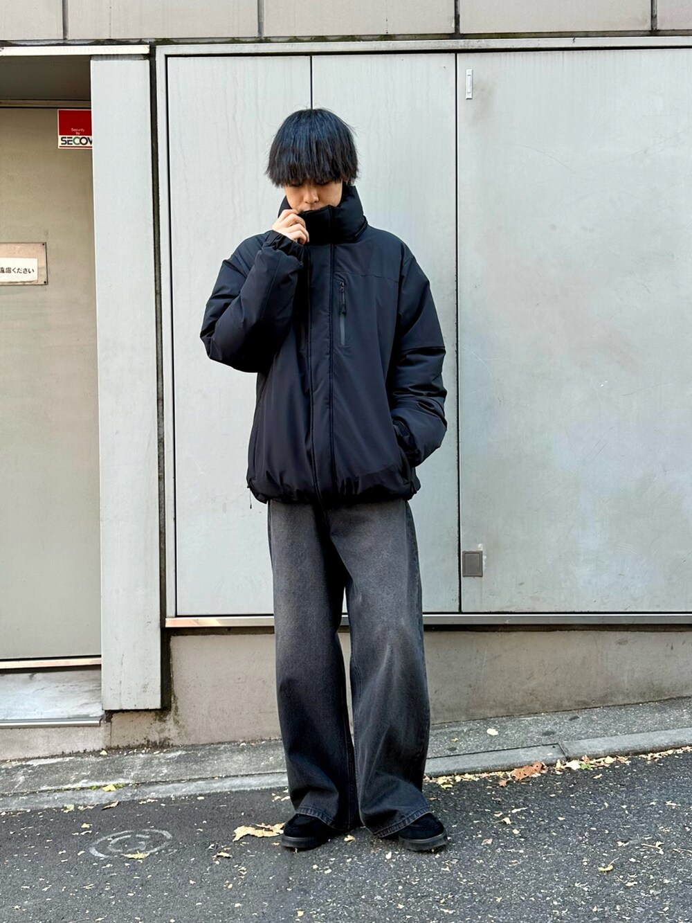 ブラック系のダウンジャケット/コート、ブラック系のデニムパンツ、ブラック系のモカシン/デッキシューズを着用したメンズの冬コーディネートの2枚目の写真