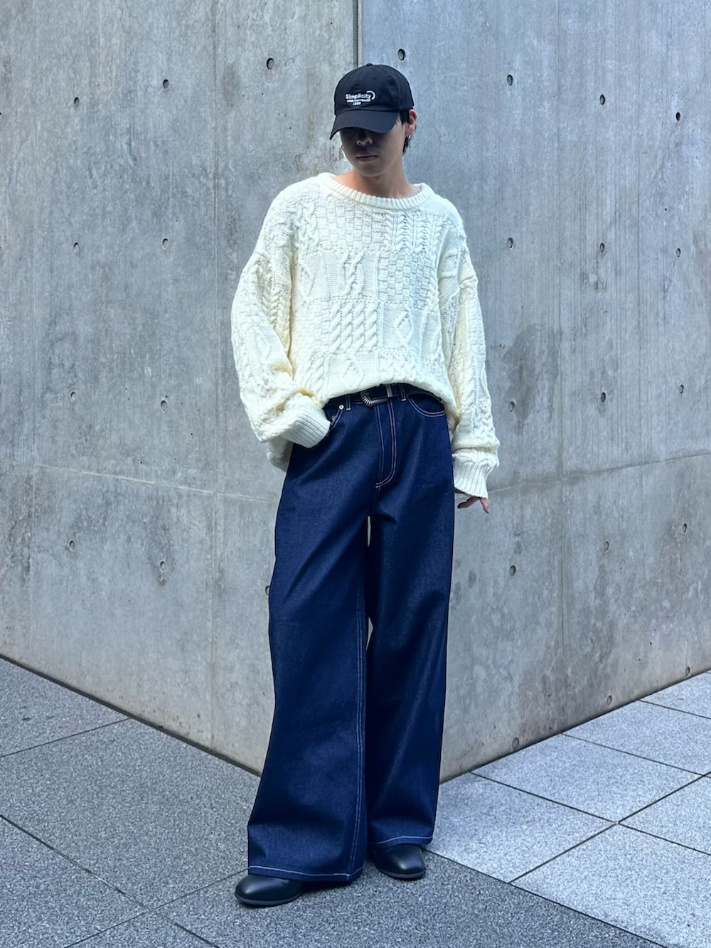 ホワイト系のニット/セーター、ブルー系のデニムパンツ、ブラック系のキャップを着用したメンズの秋コーディネートの5枚目の写真