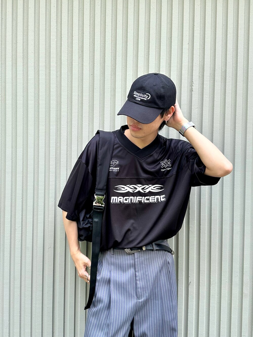 ブラック系のTシャツ/カットソー、ブラック系のショルダーバッグ、ブルー系のキャップを着用したメンズの夏コーディネートの2枚目の写真