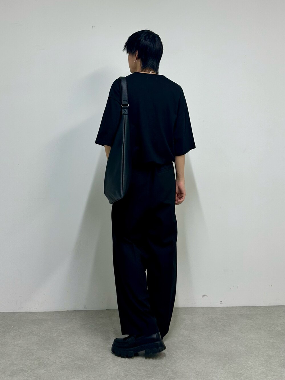 ブラック系のTシャツ/カットソー、ブラック系のスラックス、ブラック系のトートバッグを着用したメンズの夏コーディネートの3枚目の写真