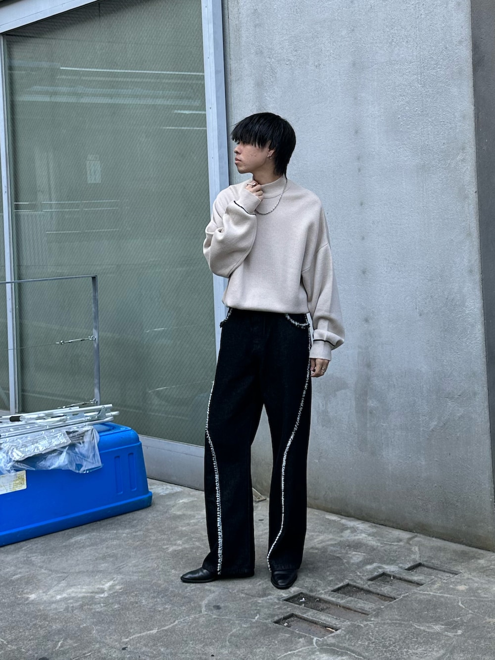 ブラック系のデニムパンツ、ベージュ系のニット/セーターを着用したメンズの秋コーディネートの2枚目の写真