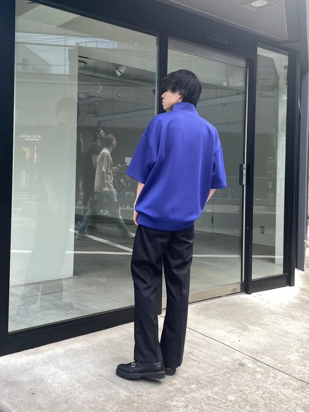 ブルー系のTシャツ/カットソー、ブラック系のスラックスを着用したメンズの春コーディネートの4枚目の写真