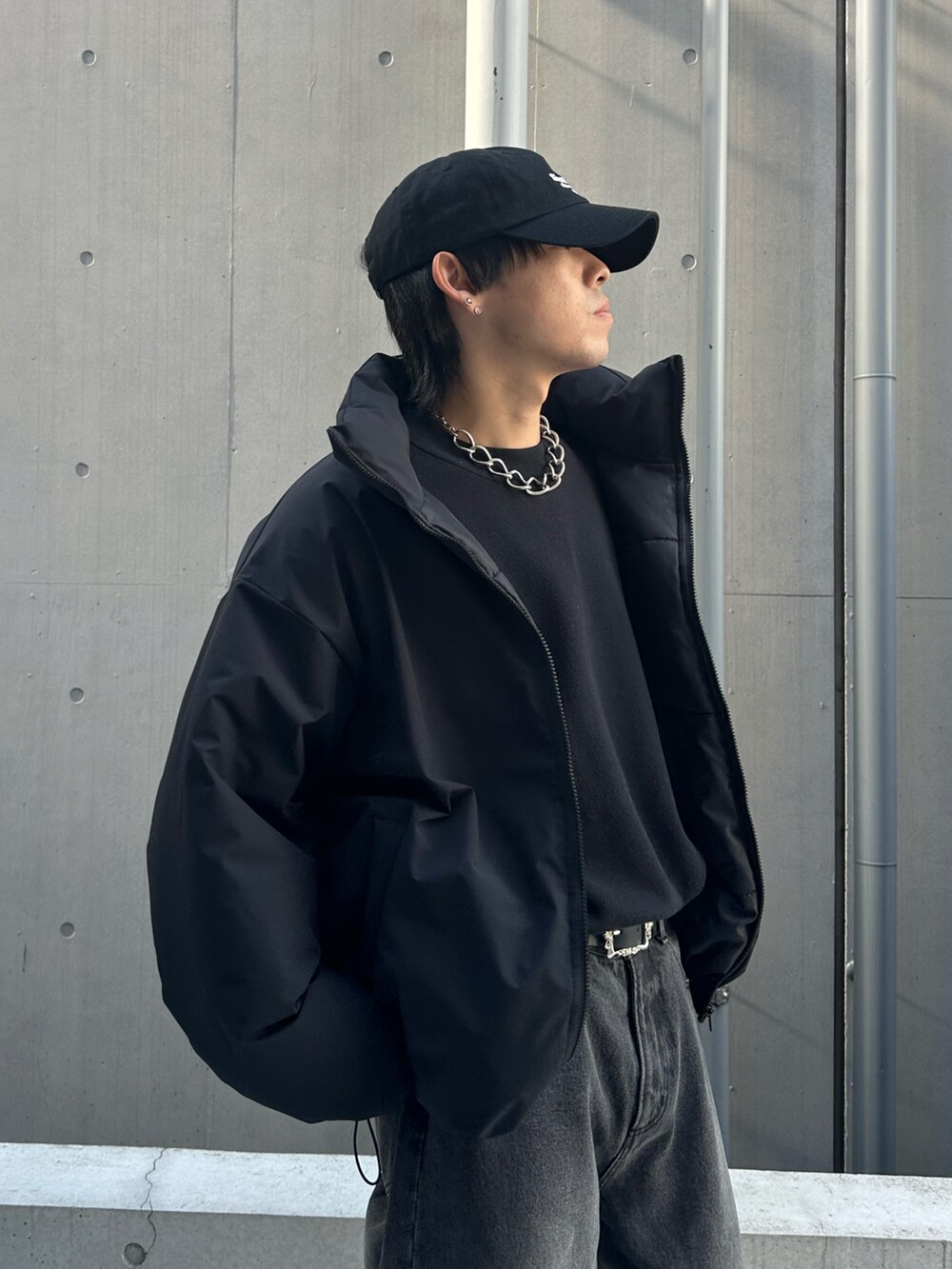 ブラック系のデニムパンツ、ブラック系のダウンジャケット/コート、ブラック系のキャップを着用したメンズの冬コーディネートの3枚目の写真