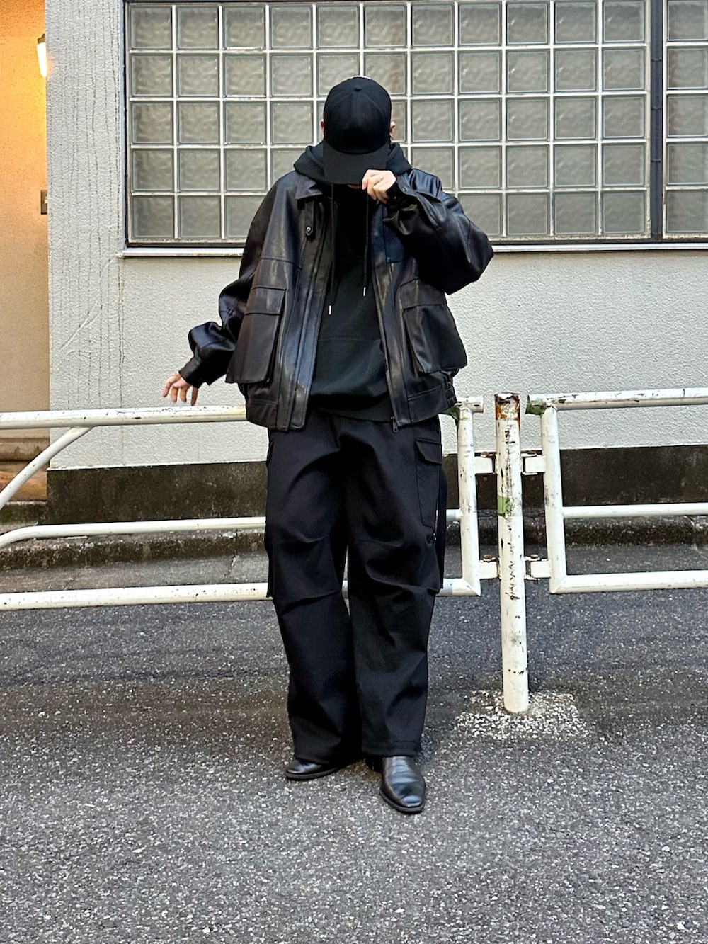 ブラック系のブルゾン、ブラック系のパーカー、ブラック系のカーゴパンツを着用したメンズの冬コーディネートの2枚目の写真