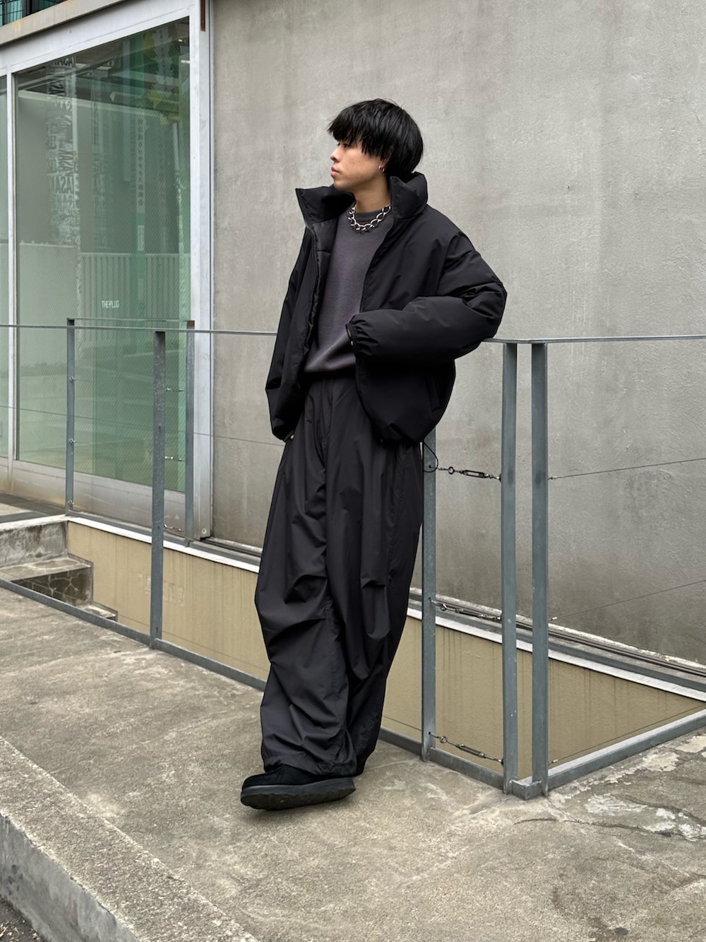 ブラック系のダウンジャケット/コート、グレー系のニット/セーター、ブラック系のその他パンツを着用したメンズの冬コーディネートの4枚目の写真