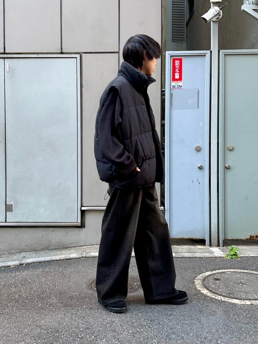 ブラック系のダウンベスト、ブラック系のニット/セーター、ブラック系のデニムパンツを着用したメンズの秋コーディネートの4枚目の写真
