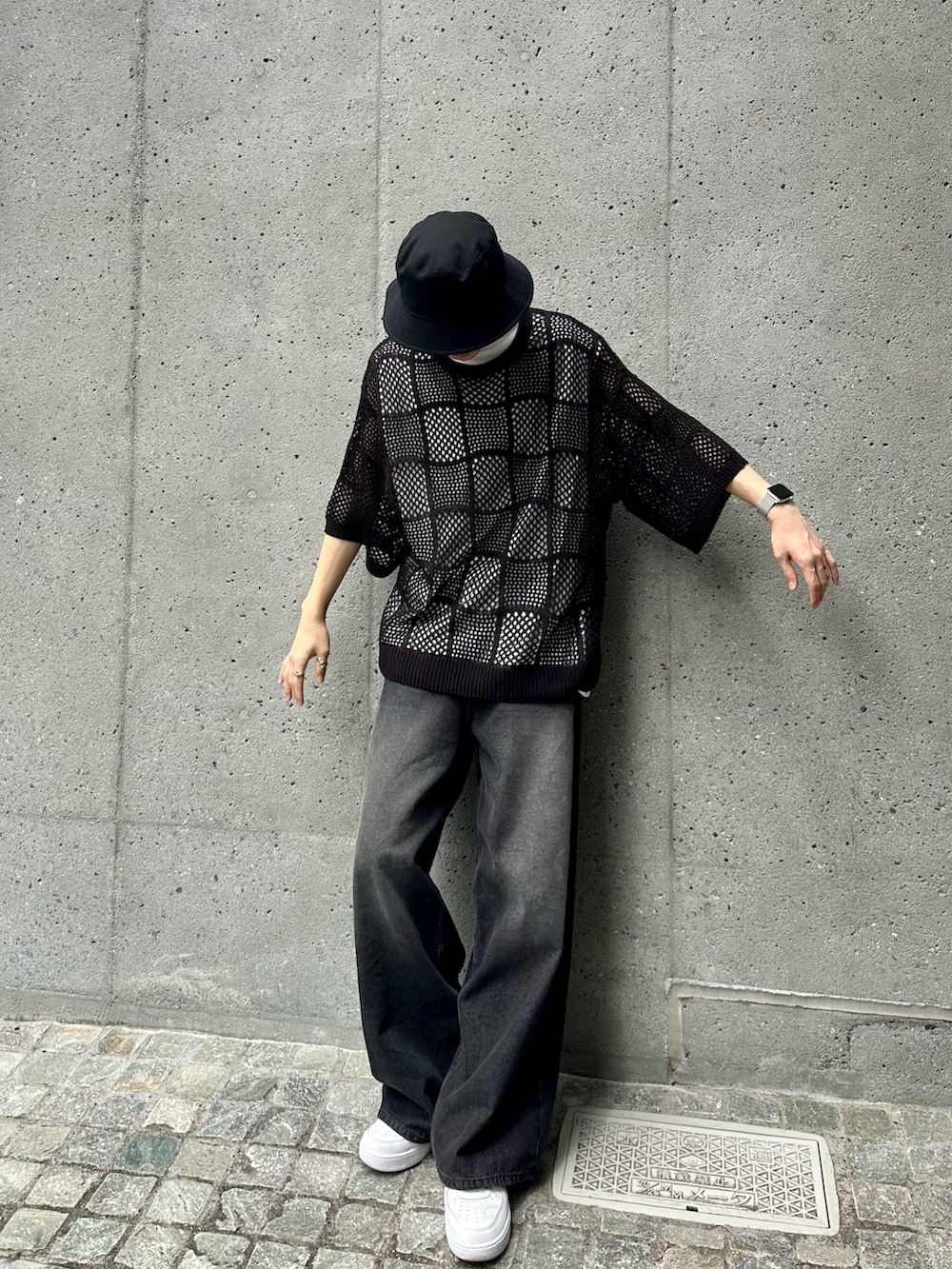 ブラック系のニット/セーター、ブラック系のデニムパンツ、ホワイト系のタンクトップを着用したメンズの夏コーディネートの3枚目の写真