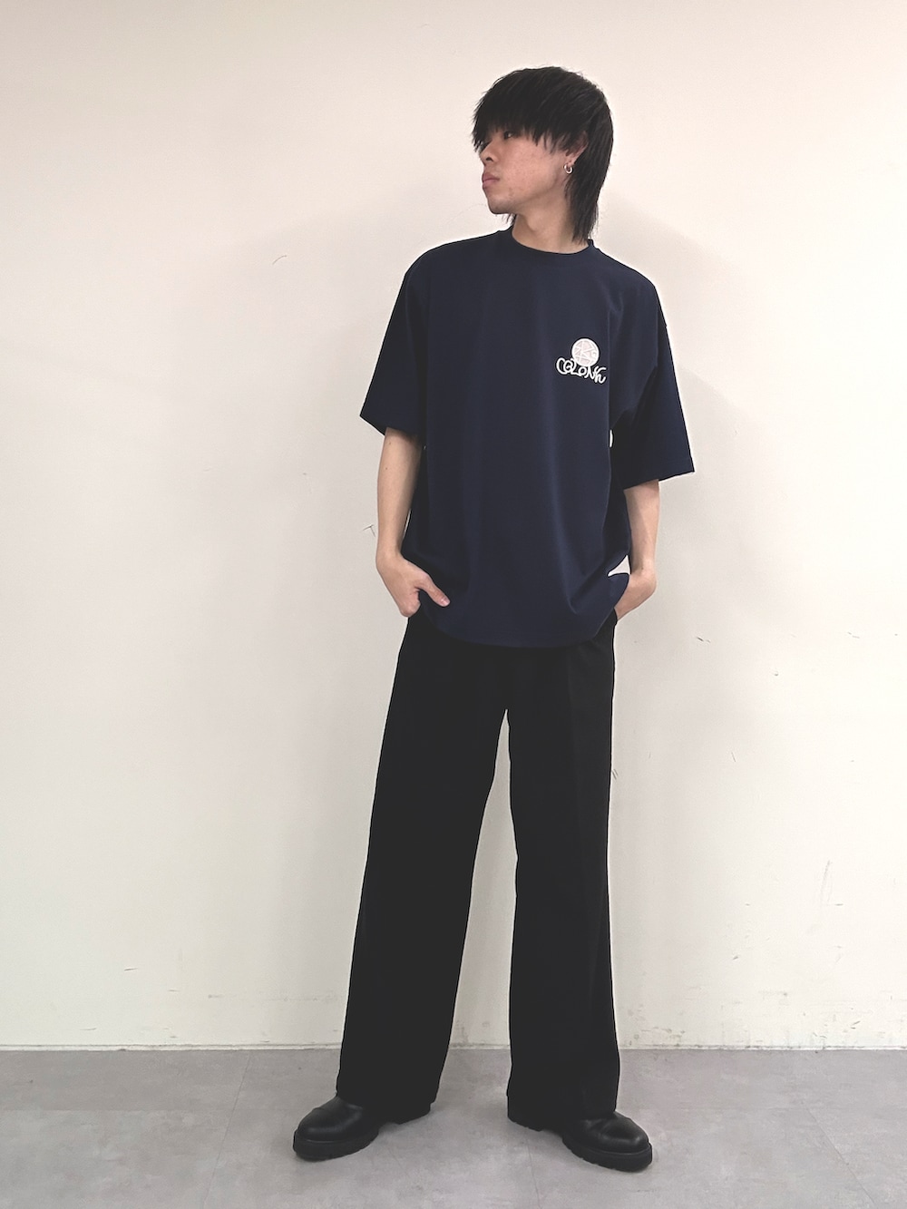 ブルー系のTシャツ/カットソー、ブラック系のスラックスを着用したメンズの春コーディネートの2枚目の写真