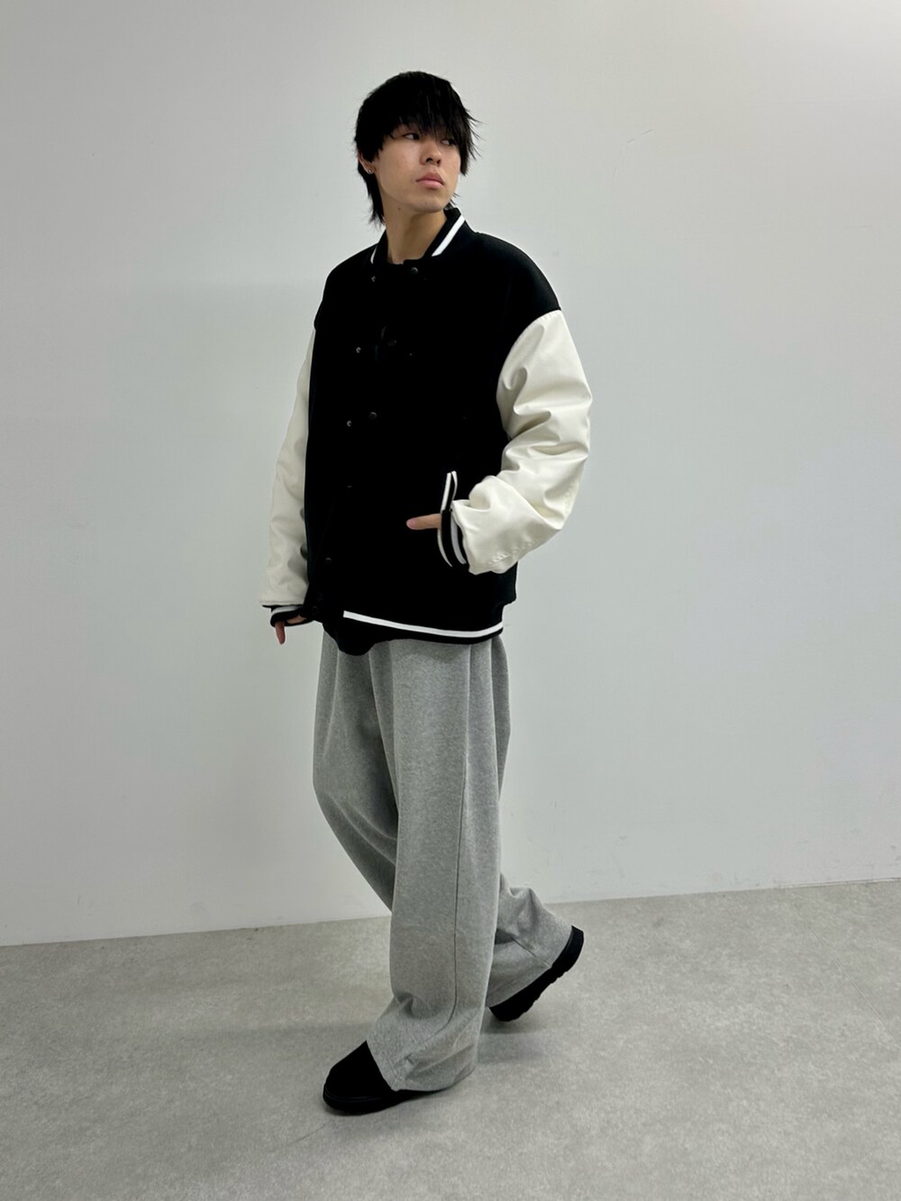 ブラック系のスタジャン、グレー系のスウェットパンツ、ブラック系のモカシン/デッキシューズを着用したメンズの秋コーディネートの4枚目の写真