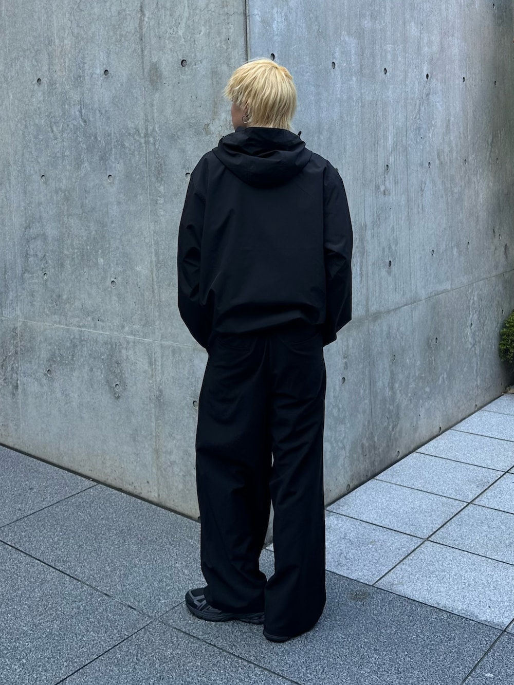 ブラック系のブルゾン、ブラック系のスラックスを着用したメンズの夏コーディネートの3枚目の写真