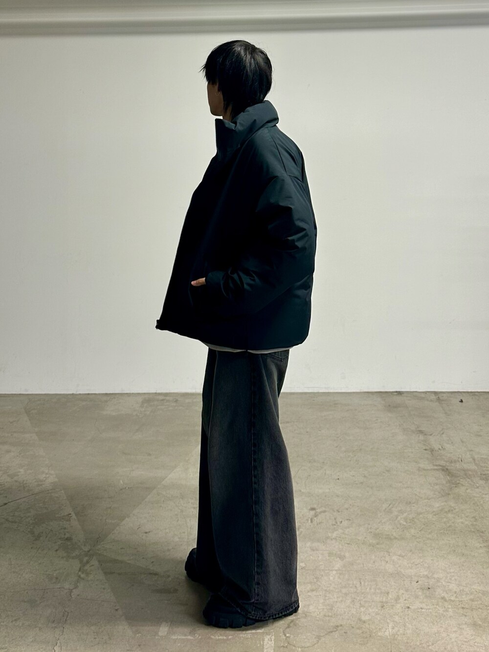 ブラック系のデニムパンツ、ブラック系のダウンジャケット/コートを着用したメンズの秋コーディネートの2枚目の写真