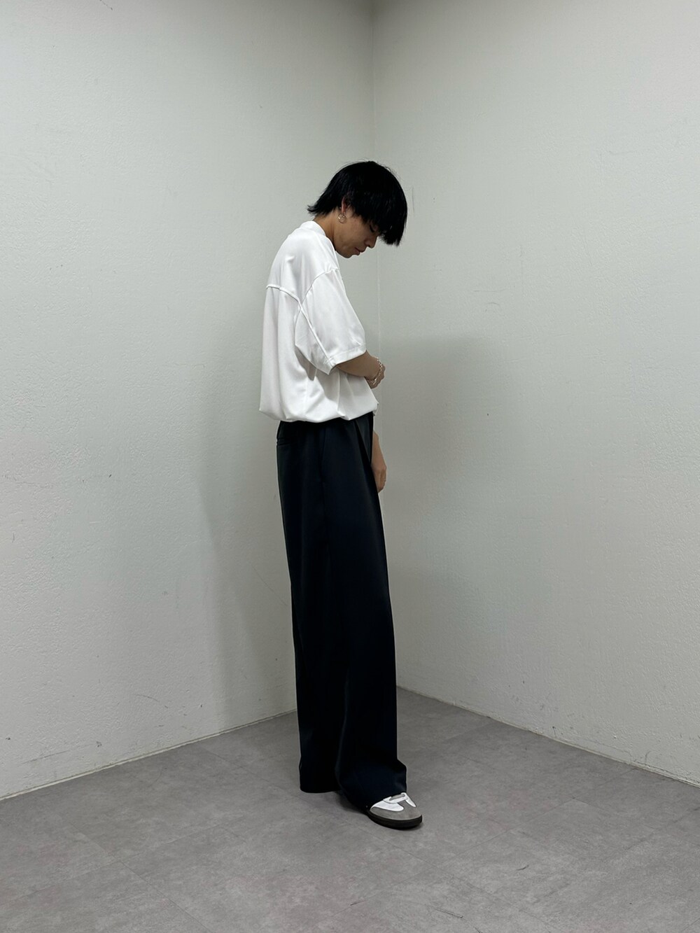 ホワイト系のTシャツ/カットソー、ブラック系のスラックスを着用したメンズの春コーディネートの4枚目の写真