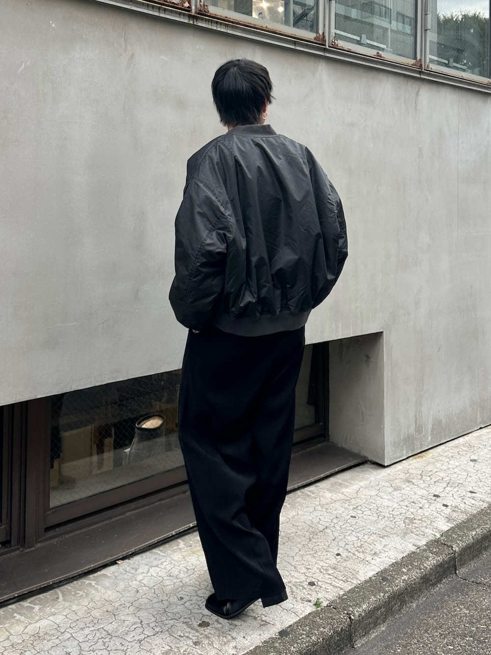 ブラック系のブルゾン、ブラック系のスラックス、ブラック系のベルトを着用したメンズの秋コーディネートの3枚目の写真